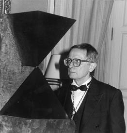 Josep M. Subirachs à côté de la sculpture <i>Métaphysique 1065</i>, pièce de la collection du Museo de la Real Academia de Bellas Artes de San Fernando de Madrid. La photographie est datée du 29 avril 1990, jour où le sculpteur catalan prononça son discours d'entrée en tant qu'académicien.